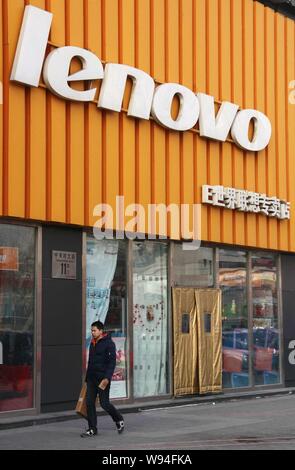 ---- Ein Fußgänger geht hinter einem Store von Lenovo in Peking, China, 7. Januar 2013. Lenovo Group Ltd. plant, ungefähr sieben weitere Flagship Store zu öffnen. Stockfoto