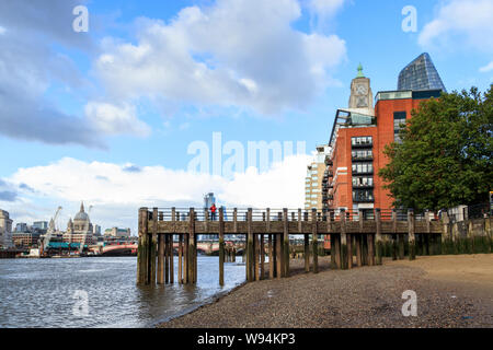 Blick von der Themse bei Ebbe, St Paul's Cathedral und die Stadt in der Ferne, am Pier in Gabriel's Wharf im Vordergrund, London, UK Stockfoto