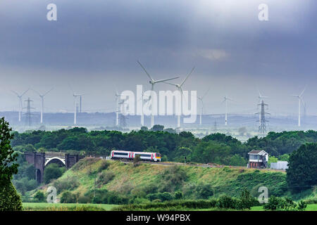 Ein Transport für Wales Class 175 Diesel Zug passiert Frodsham signalbox. Frodsham Sümpfe windfarm im Hintergrund. Stockfoto