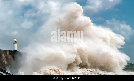 Riesigen Ozean Wellen in ein Meer von Wand- und Leuchtturm (Porthcawl, South Wales, UK) Stockfoto