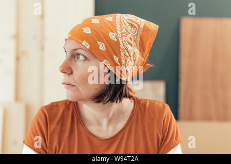 Selbst Frau Zimmermann beschäftigt, die man vom Fenster aus sieht Portrait in ihrem kleinen Geschäft Holzarbeiten workshop Stockfoto