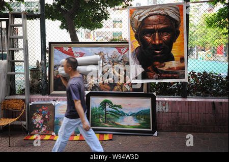 Ein Fußgänger geht Vergangenheit Ölgemälde zum Verkauf auf der Straße zum Ölgemälde-Dorf Dafen, Shenzhen City, South China Guangdong Provinz, 19 Septemb Stockfoto