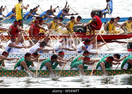 Die Teilnehmer messen sich in einem Drachenboot rennen in einem Fluss der Dragon Boat Festival in Sanya City, South China Hainan Provinz, 23. Juni 2012 zu feiern. Stockfoto