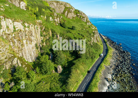 Nordirland, Großbritannien. Die Antrim Coast Road alias Causeway Coastal Route in der Nähe von Ballygalley Kopf und Resort. Eine der schönsten Küstenstraßen Europas. Stockfoto
