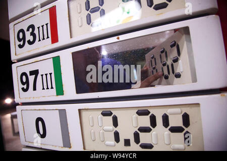 Ein chinesischer Arbeiter aktuelles Treibstoffpreise an einer Tankstelle von Sinopec in Beijing City, South China Hainan Provinz, 10. Juli 2012. China zerschnitten Kraftstoff pric Stockfoto