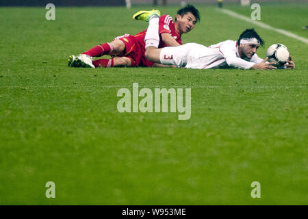 Yu Hanchao von China, Links, Herausforderungen Suleiman Mawafaq Al-Salman Jordanien während einer Gruppe ein Spiel der WM-Qualifikationsspiel 2014 in Guangzhou City, s Stockfoto