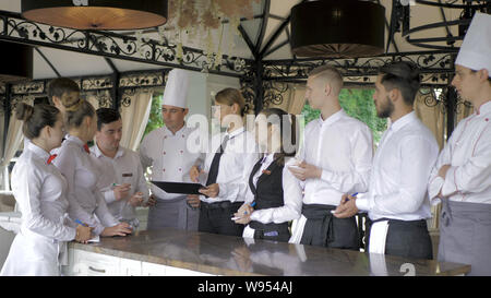 Restaurant Manager und sein Personal in Terrasse. Interaktion Küchenchef im Restaurant zu Kopf Stockfoto