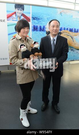 Chinesischen Olympischen Swimmingpool Meister Ihr Shiwen, Links, ist Spielzeug Hunde und ein Modell auto während einer Zeremonie an einem BMW Dealership in Hangzhou ci dargestellt Stockfoto