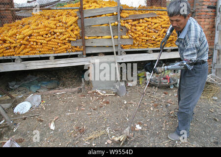 ---- Sonne Jifa macht die Arbeit am Hof mit seiner selbstgebauten künstliche Hände in der Stadt Jilin im Nordosten Chinas in der Provinz Jilin, 13. Oktober 2005. Sie können gewonnen Stockfoto