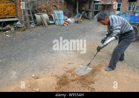 ---- Sonne Jifa macht die Arbeit am Hof mit seiner selbstgebauten künstliche Hände in der Stadt Jilin im Nordosten Chinas in der Provinz Jilin, 13. Oktober 2005. Sie können gewonnen Stockfoto