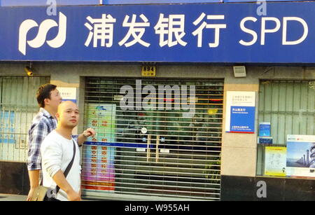 ---- Fußgänger vorbei an einem Zweig von Shanghai Pudong Development (SPD) Bank in Shanghai, China, 23. September 2011. Shanghai Pudong Development Stockfoto