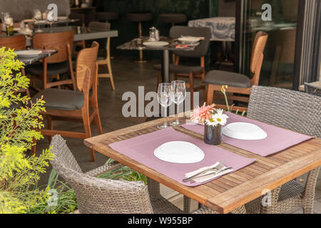 Außerhalb der Tabelle mit Platte Einstellungen und Blumen in der Mitte eingestellt Stockfoto