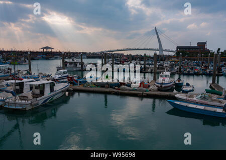 Sonnenstrahlen, Sonnenlicht strömt durch kleine Löcher in die Wolken, Lover's Bridge, kleine Fischerboote, Tamsui Fisherman's Wharf, Taipei, Taiwan Stockfoto