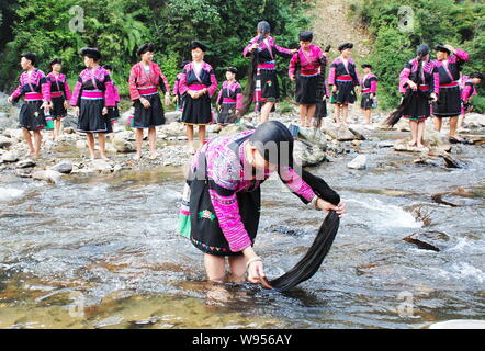 Frauen der Roten Yao ethnische Minderheit ihre langen Haare Waschen im Fluss in Huangluo Yao Dorf, Longsheng Grafschaft, der Stadt Guilin, South China Guangxi Stockfoto