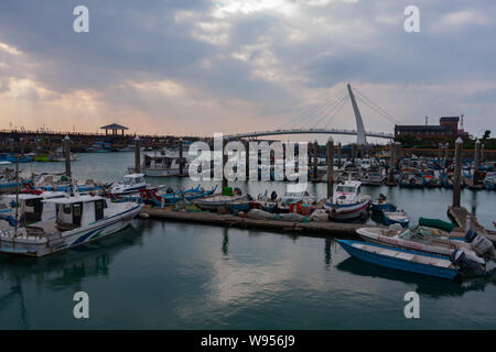 Sonnenstrahlen, Sonnenlicht strömt durch kleine Löcher in die Wolken, Lover's Bridge, kleine Fischerboote, Tamsui Fisherman's Wharf, Taipei, Taiwan Stockfoto