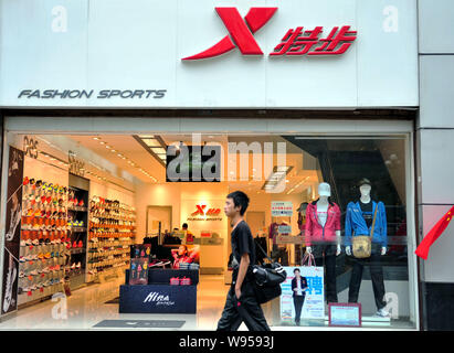 ---- Ein Fußgänger geht hinter einem Xtep store in Nanjing, Provinz Jiangsu, China, 29. September 2011. China Bekleidungsindustrie ist mit Stockfoto