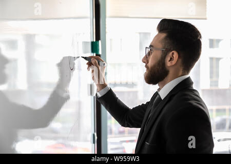 Tausendjährige Geschäftsmann Brille Zeichnung auf dem Flipchart Nahaufnahme Stockfoto