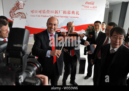 Muhtar Kent, Mitte, Vorsitzender und CEO von The Coca-Cola Company, spielt Violine bei der Eröffnung des Coca-Cola Yingkou Werk in Yingkou Stadt, Stockfoto