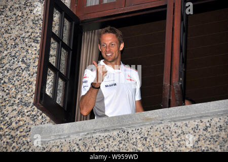 Britische F1 Fahrer Jenson Button von McLaren-Mercedes Team stellt durch das Fenster eines privaten Apartments während einer Werbeveranstaltung in Shanghai, China, Stockfoto