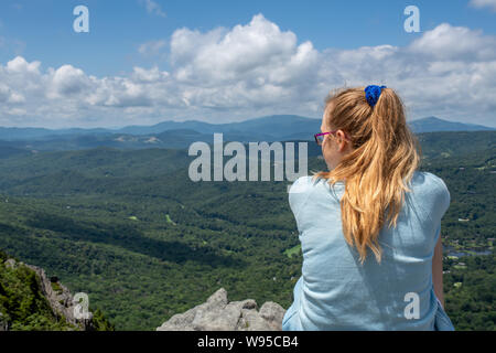 Ein Mädchen auf einem Felsvorsprung in der Nähe der Oberseite der Grandfather Mountain in North Carolina, in der Nähe von Blowing Rock, Boone, Beech Mountain Stockfoto