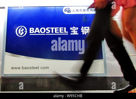 ---- Fußgänger vorbei an einer Werbung für Baosteel (Baoshan Iron & Steel Co., Ltd.) in Shanghai, China, 9. September 2011. Baosteel Inc. Stockfoto