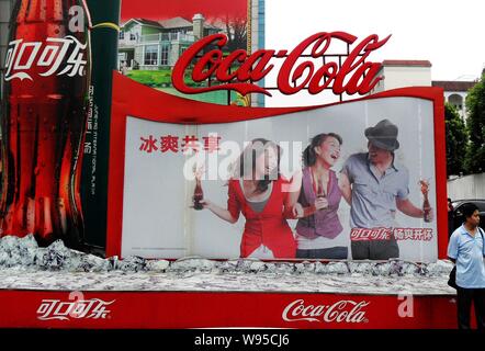 ---- Ein fussgänger wird durch eine Anschlagtafel für Coca-Cola in Yichang gesehen, Zentrale China Provinz Hubei, 25. Januar 2012. Eine Eröffnungsfeier fand ich Stockfoto