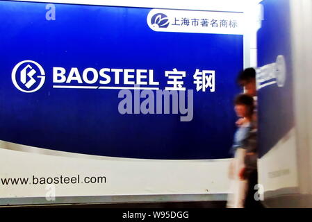 ---- Fußgänger vorbei an einer Werbung für Baosteel (Baoshan Iron & Steel Co., Ltd.) in Shanghai, China, 9. September 2011. Die baosteel Gro Stockfoto