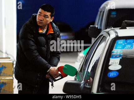 Eine chinesische Fahrer tankt sein Auto an einer Tankstelle in Conghua City, East China Provinz Jiangxi, 7. Februar 2012. China warf die Decke für reta Stockfoto