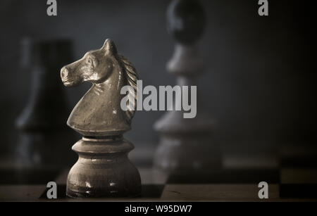 Hölzerne Schachfiguren auf einem alten Schachbrett. Stockfoto