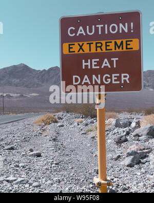 Verkehrsschilder vor gefährlich hohen Temperaturen tagsüber im Death Valley. Stockfoto