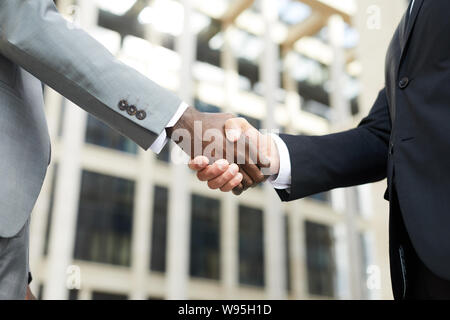 Nahaufnahme der multiethnischen Geschäftspartner stehen und die Hände schütteln während der Sitzung im Freien Stockfoto