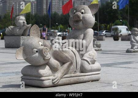 Eine steinerne Skulptur von zwei Schweine, die wie Paarung zu schauen auf dem Platz vor dem Wahrzeichen Bau angezeigt ist, die Zentrale Ebene Blessednes Stockfoto