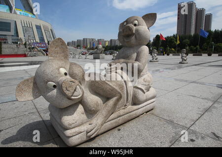 Eine steinerne Skulptur von zwei Schweine, die wie Paarung zu schauen auf dem Platz vor dem Wahrzeichen Bau angezeigt ist, die Zentrale Ebene Blessednes Stockfoto