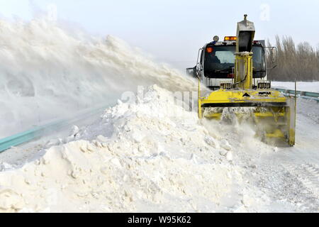 Ein Fahrzeug genehmigt Schnee auf eine Schnellstraße in Urumqi im Nordwesten Chinas Autonome Region Xinjiang Uygur, 23. Dezember 2012. Temperaturen in Peking plung Stockfoto