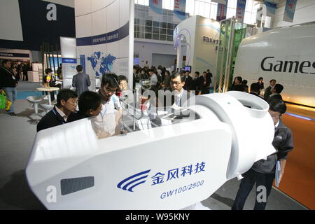 ------ Chinesischer Besucher an einem Modell Windkraftanlage auf dem Stand von Xinjiang Goldwind Wissenschaft & Technik Unternehmen während einer Messe in Peking, China, Stockfoto