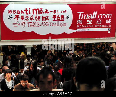 ---- Fußgänger vorbei an einer Werbung für Online Shopping website Tmall.com in einer U-Bahn-Station in Shanghai, China, 13. Oktober 2011. Alib Stockfoto