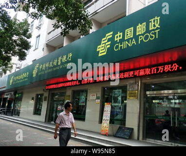 ---- Ein Fußgänger geht vorbei an einem Zweig der Postsparkasse von China (Psbc) in Shanghai, China, 16. August 2011. Die Postsparkasse von China Stockfoto