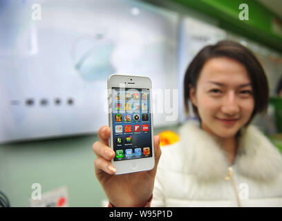 Eine junge chinesische Frau zeigt ein Apple iPhone 5 Smartphone Sie in einem Geschäft in Yangzhou Stadt gekauft, East China Jiangsu Provinz, 13. Dezember 2012. Die Stockfoto