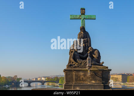 Bildhauerkunst der Pieta oder Statue der Beweinung Christi, stand am Geländer der Karlsbrücke und den Hintergrund von Moldau und Legionen Brücke. Stockfoto