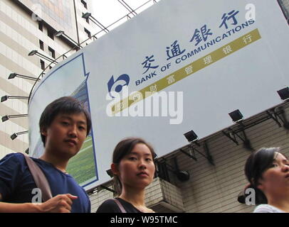 ---- Fußgänger vorbei an einer Werbung für Bank für Kommunikation (BoCom) in Shanghai, China, 27. August 2011. Bank von Communications Corp., Stockfoto