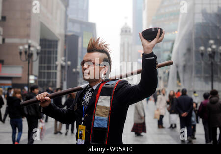 Zhou Fei, wie die Angesagtesten Bettler in China bekannt ist, stellt in einer Fußgängerzone in Chongqing, China, 23. Februar 2012. Anzug, gespritzt Stockfoto