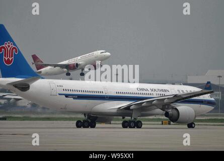 --FILE - ein Airbus A330-200 Düsenflugzeug von China Southern Airlines, front, bewegt sich die Landebahn als eine Pflanze von Juneyao Airlines am Flughafen Hongqiao I Stockfoto