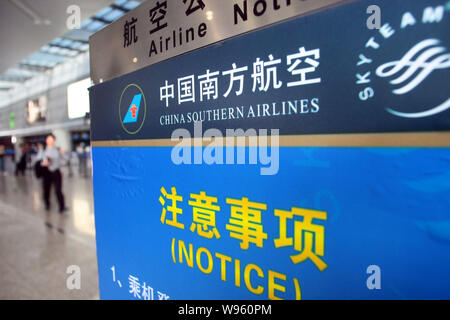 ---- Passagiere vorbei an einem Namensschild von China Southern Airlines am Internationalen Flughafen Shanghai Hongqiao in Shanghai, China, 27. März 2012. Ch Stockfoto