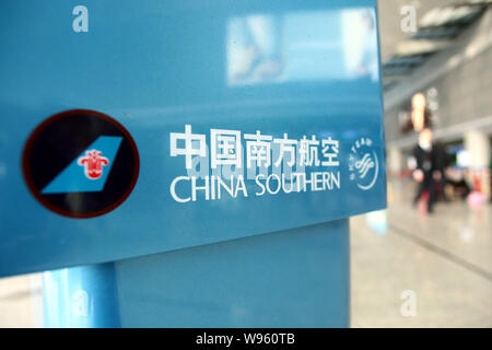 ---- Passagiere vorbei an einem Namensschild von China Southern Airlines am Internationalen Flughafen Shanghai Hongqiao in Shanghai, China, 27. März 2012. Ch Stockfoto