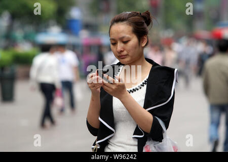 --File - eine Frau mit ihrem Mobiltelefon in einer Straße in Shanghai, China, 27. April 2011. China erreicht einen Meilenstein im letzten Monat, wenn die Benutzer von Mobiltelefonen Stockfoto