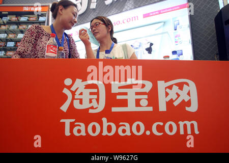 ------ Chinesische Mitarbeiter sind auf dem Stand von Taobao.com während einer Messe in Shanghai, China, 28. Juli 2011 gesehen. Eine Reihe von Mitarbeitern, die an Taobao, China la Stockfoto