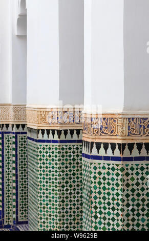 Detail der Spalten in Islamischen design Mosaik fertigen Kacheln und arabische Kalligraphie in Stuck. Der historischen Medina von Marrakesch, Marokko. UNESCO-Website. Stockfoto