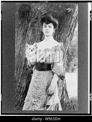 Alice Roosevelt Longworth, drei-viertel länge Porträt, stand vor der Baum, mit leicht nach links, kleiner Hund Stockfoto