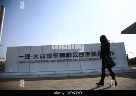 ---- Eine junge chinesische Frau geht hinter dem Tor der automatische Anlage von FAW-Volkswagen Automobile Co., Ltd. mit Niederlassung in Chengdu Chengdu City, im Südwesten von C Stockfoto