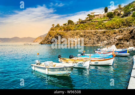 Manarola, Cinque Terre - Angeln Boote in der Nähe von romantischen kleinen Dorf auf einer Klippe mit Blick auf das Meer. Der Nationalpark der Cinque Terre mit seinen zerklüfteten Küste ist f Stockfoto